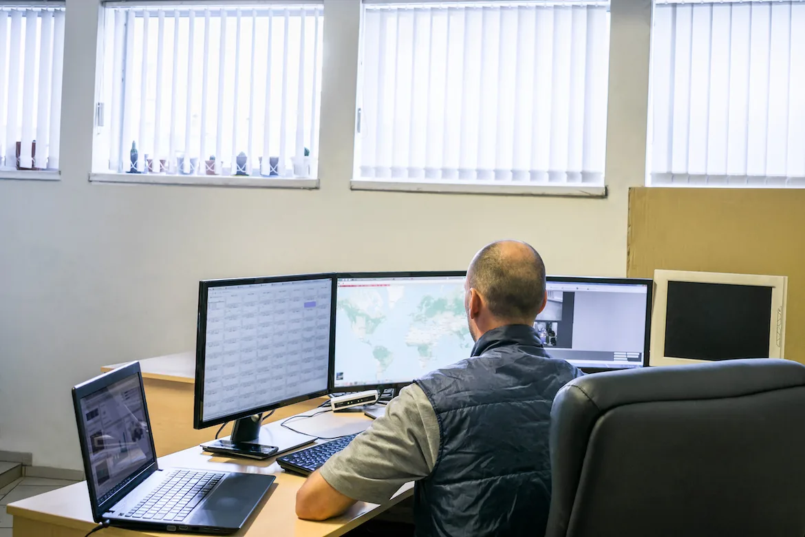 An operator works at a dispatch position with several monitors